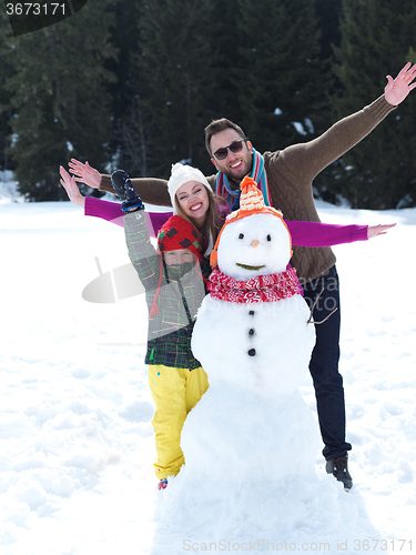 Image of happy family making snowman