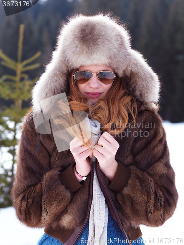Image of portrait of beautiful young redhair woman in snow scenery