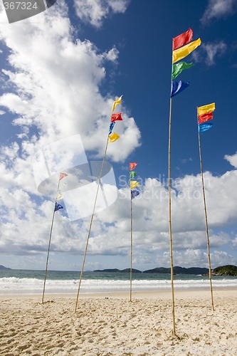 Image of Flagpoles with colorful flags on the beach