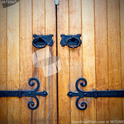 Image of handle in london antique brown door  rusty  brass nail and light