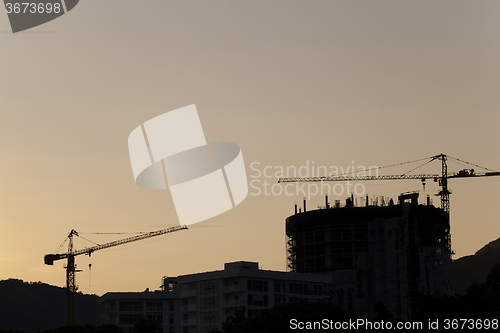 Image of construction cranes at sunset  