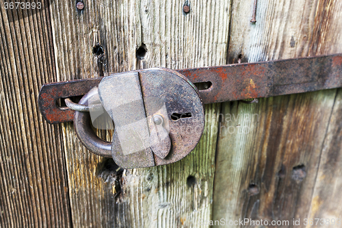 Image of  padlock .  wooden door