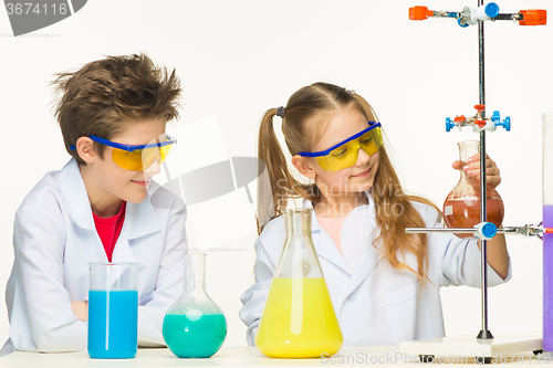 Image of Two cute children at chemistry lesson making experiments