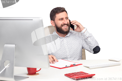 Image of Portrait of businessman talking on mobile phone in office