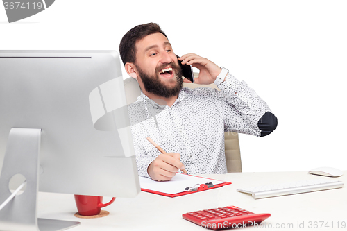 Image of Portrait of businessman talking on mobile phone in office