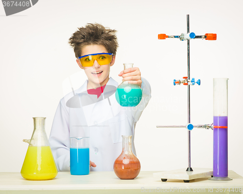 Image of Little boy as chemist doing experiment with chemical fluid 
