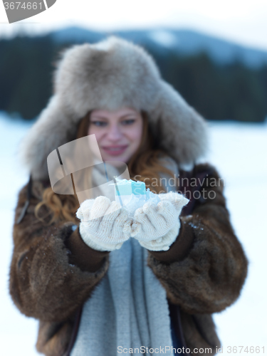 Image of portrait of  girl with gift at winter scene and snow in backgron