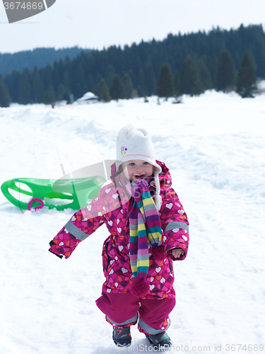 Image of little baby girl have fun on fresh snow