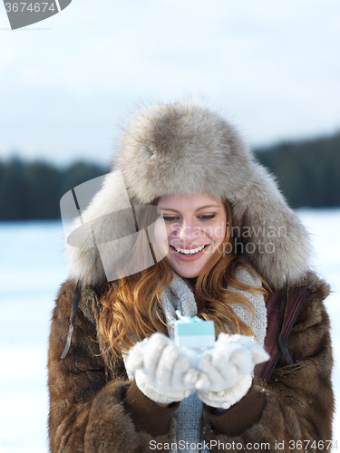 Image of portrait of  girl with gift at winter scene and snow in backgron