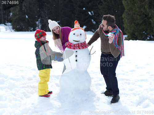 Image of happy family making snowman