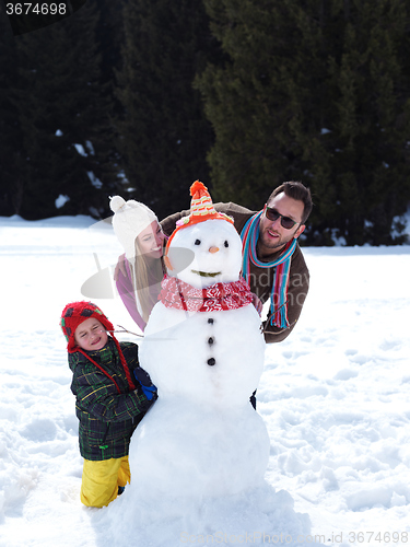 Image of happy family making snowman