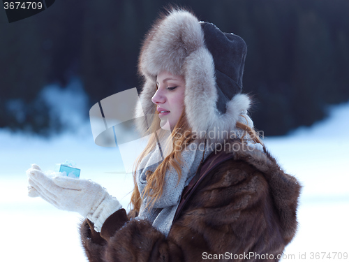 Image of portrait of  girl with gift at winter scene and snow in backgron