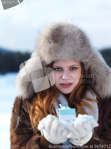 Image of portrait of  girl with gift at winter scene and snow in backgron
