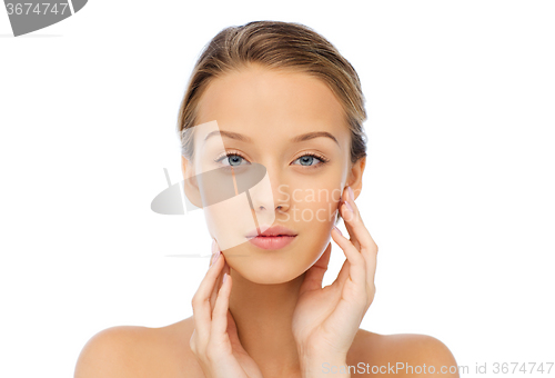 Image of young woman touching her face