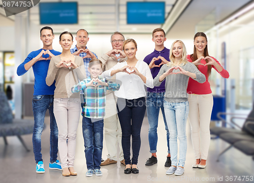 Image of group of smiling people showing heart hand sign