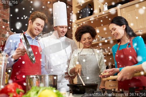 Image of happy friends and chef cook cooking in kitchen