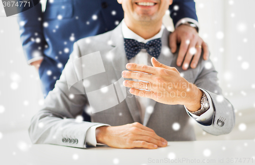 Image of close up of male gay couple with wedding rings on