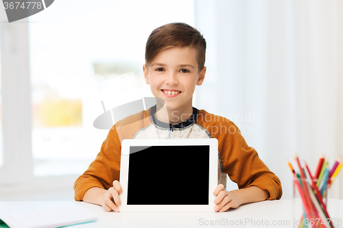 Image of smiling boy showing tablet pc blank screen at home