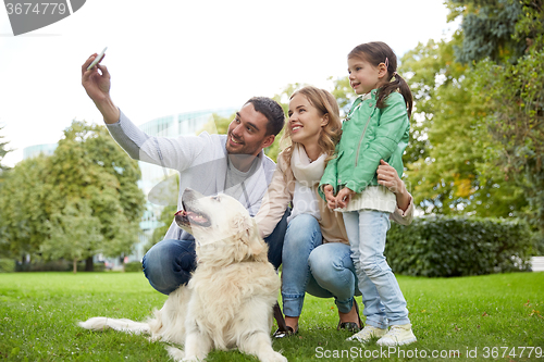 Image of happy family with dog taking selfie by smartphone