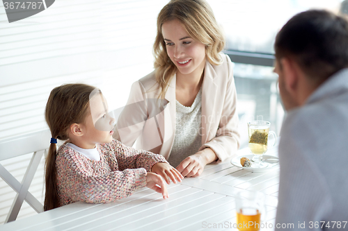 Image of happy family having dinner at restaurant or cafe