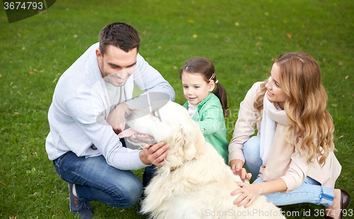 Image of happy family with labrador retriever dog in park