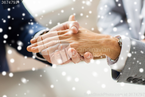 Image of close up of male gay couple hands and wedding ring