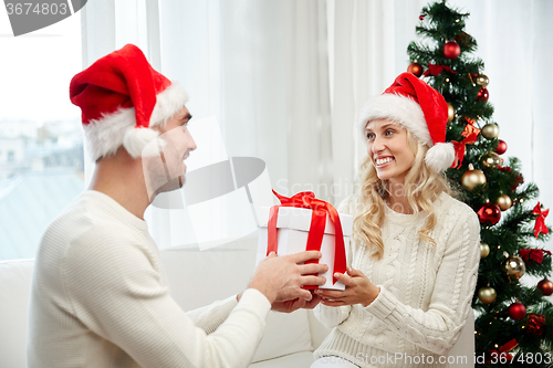 Image of happy couple at home with christmas gift box