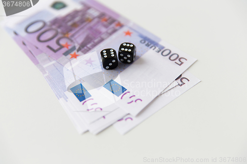 Image of close up of black dice and euro cash money