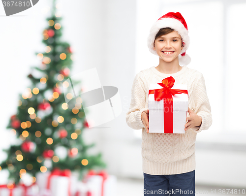 Image of smiling happy boy in santa hat with gift box
