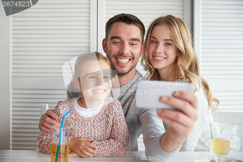 Image of happy family taking selfie at restaurant