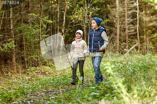 Image of two happy kids walking along forest path