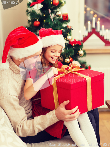 Image of smiling father and daughter opening gift box