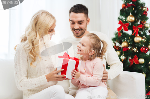 Image of happy family at home with christmas tree