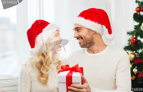 Image of happy couple at home with christmas gift box
