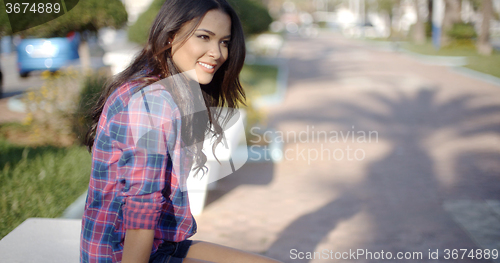 Image of Young Woman Sitting In A Summer Park