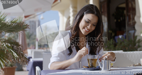 Image of Girl Sitting At Cafe With Cup Of Tea