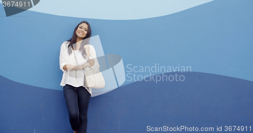 Image of Stylish Cool Girl Against A Blue Wall