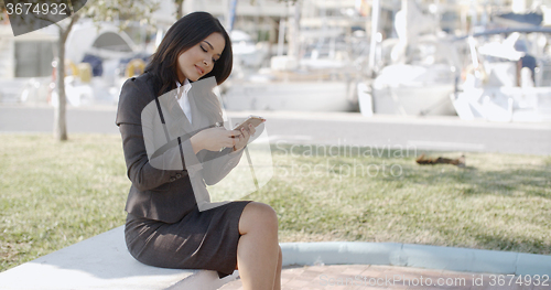 Image of Woman Holding A Phone On The Street