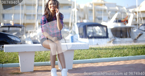 Image of Young Woman Sitting On Bench In Harbor