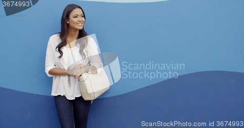 Image of Stylish Cool Girl Against A Blue Wall