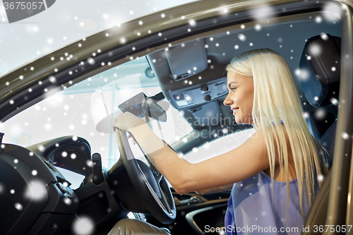 Image of happy woman inside car in auto show or salon