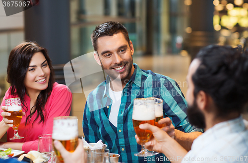 Image of friends dining and drinking beer at restaurant