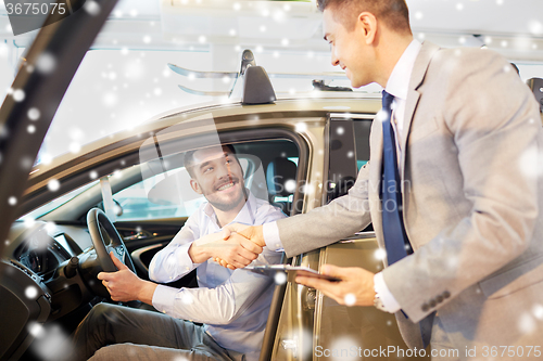 Image of happy man with car dealer in auto show or salon