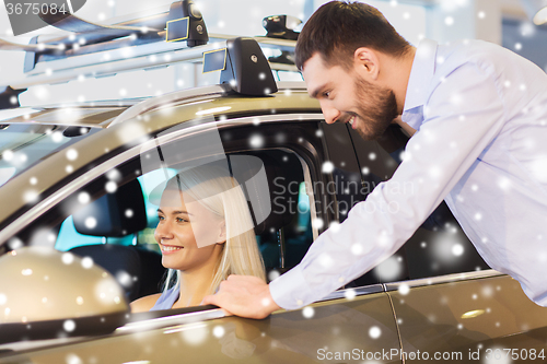 Image of happy couple buying car in auto show or salon