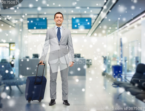 Image of happy businessman in suit with travel bag