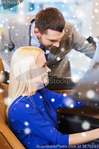 Image of happy couple buying car in auto show or salon