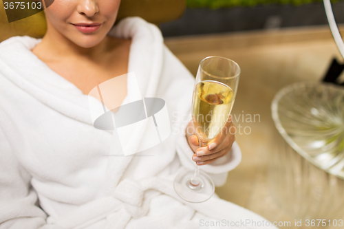 Image of close up of young woman drinking champagne at spa