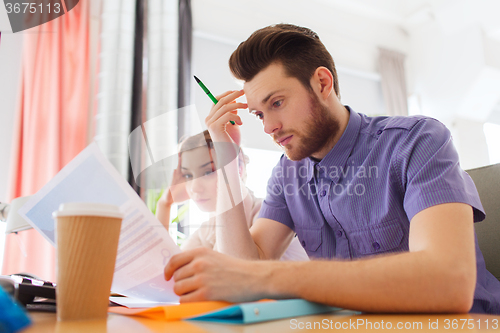 Image of creative team with computer and papers in office