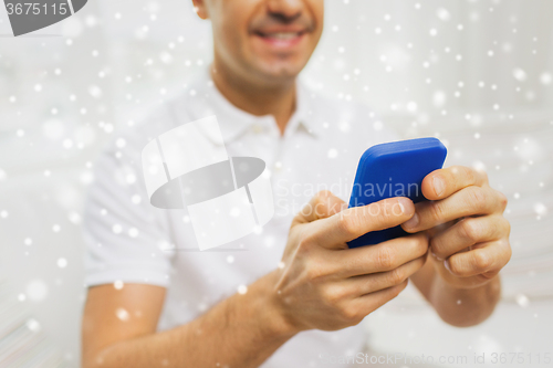 Image of close up of happy man with smartphone at home