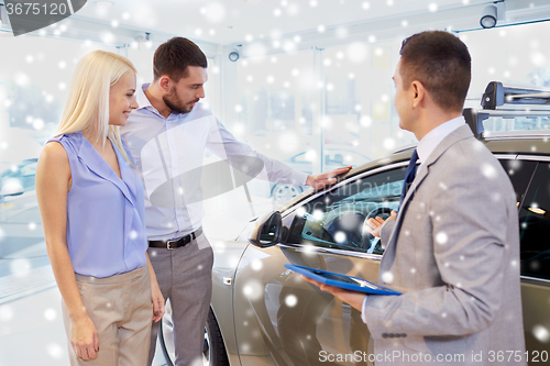 Image of happy couple with car dealer in auto show or salon